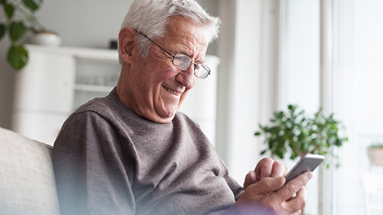 A senior man scheduling an appointment on a mobile phone device.