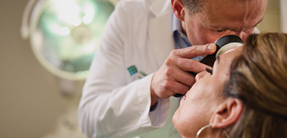 Dermatologist examining a patient's face during a skin cancer screening at AHN.