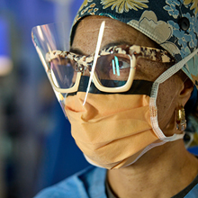 Doctor wearing surgical mask and eye protection, preparing for Mohs surgery to remove squamous cell carcinoma.