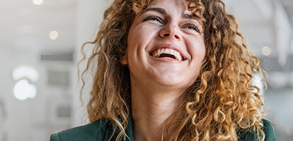 A young woman laughing and looking upwards. 