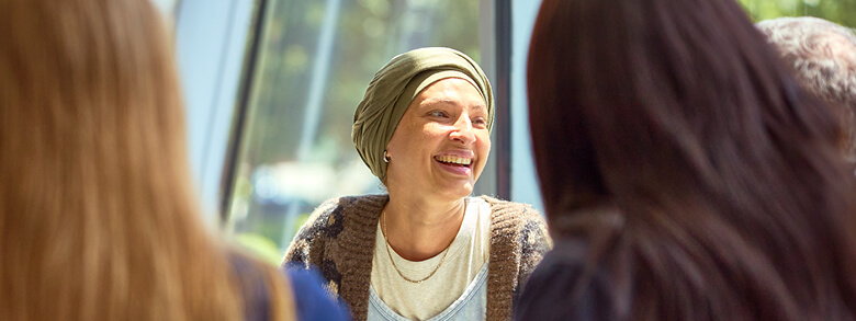 Cancer patient smiling while talking to members of her AHN Cancer Navigation team 