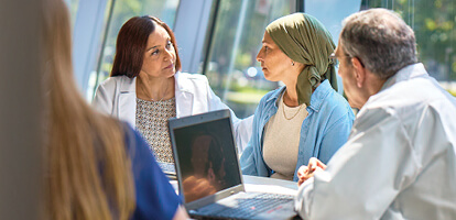 Cancer specialists talking with patient in a meeting room