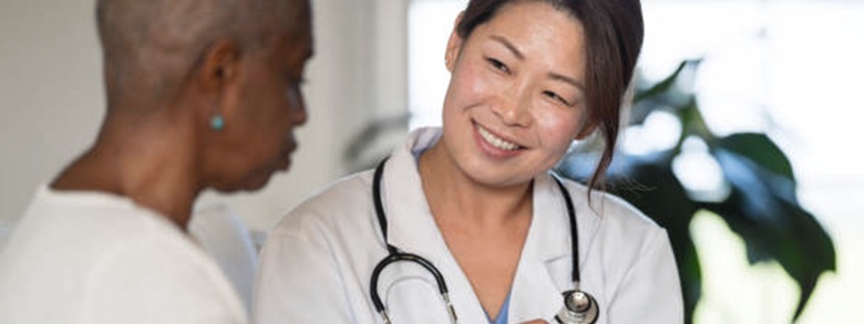 Doctor smiling as she talks to a patient 