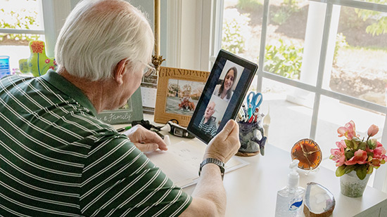 An elderly man on a telehealth video visit talking to his primary care physician.